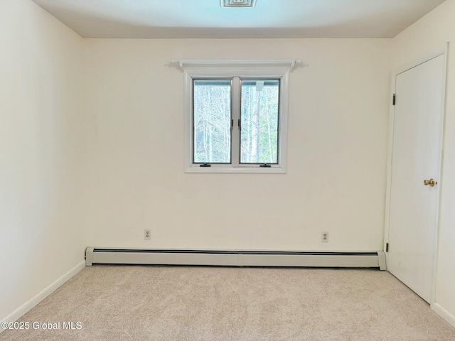 empty room featuring baseboards, light carpet, and a baseboard radiator