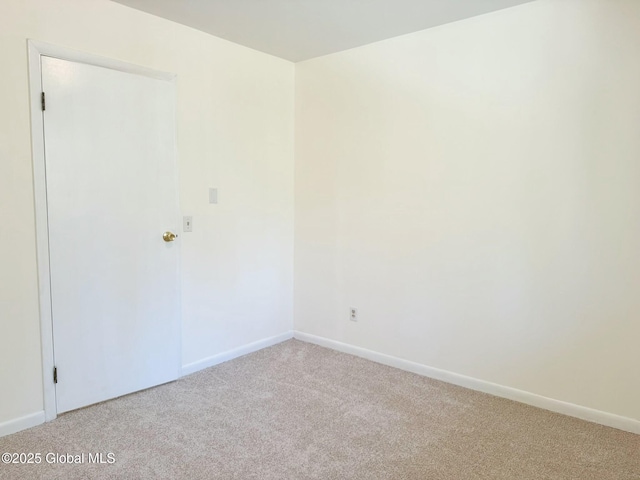 empty room with light colored carpet and baseboards