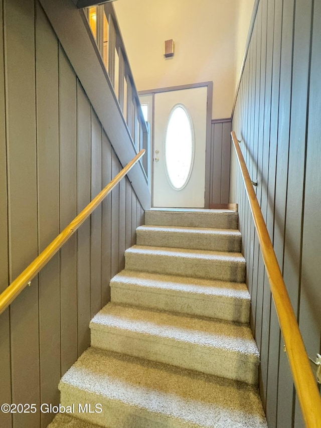 stairs featuring a wainscoted wall and a decorative wall