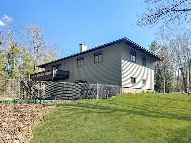 view of property exterior with fence, a yard, and a chimney