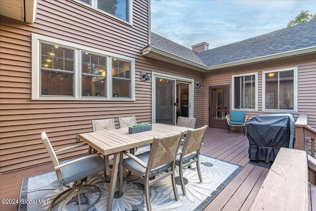 wooden terrace featuring grilling area and outdoor dining space