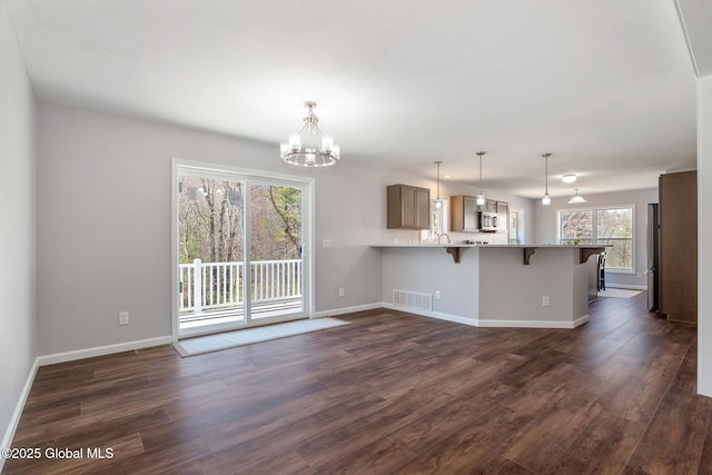 152 Ingersoll Rd, Wilton, NY 12866 - kitchen featuring a kitchen breakfast bar, stainless steel microwave, a chandelier, dark wood finished floors, and a peninsula