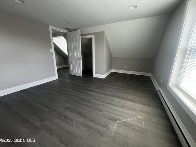 additional living space with baseboards, recessed lighting, a baseboard heating unit, and dark wood-style floors