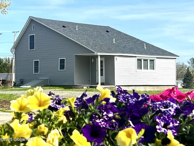 rear view of house with a shingled roof