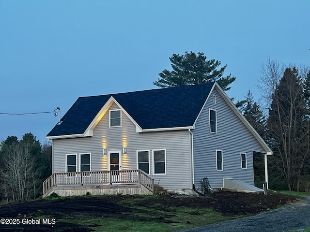 view of front of property featuring roof with shingles and a deck