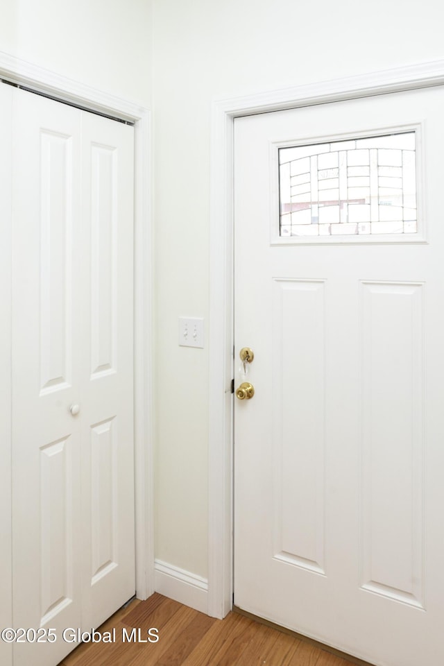 doorway to outside with light wood-type flooring and baseboards
