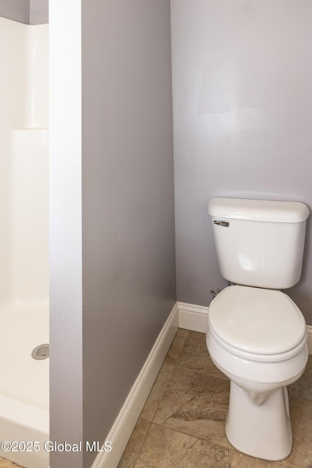 full bath with toilet, a shower, baseboards, and tile patterned flooring