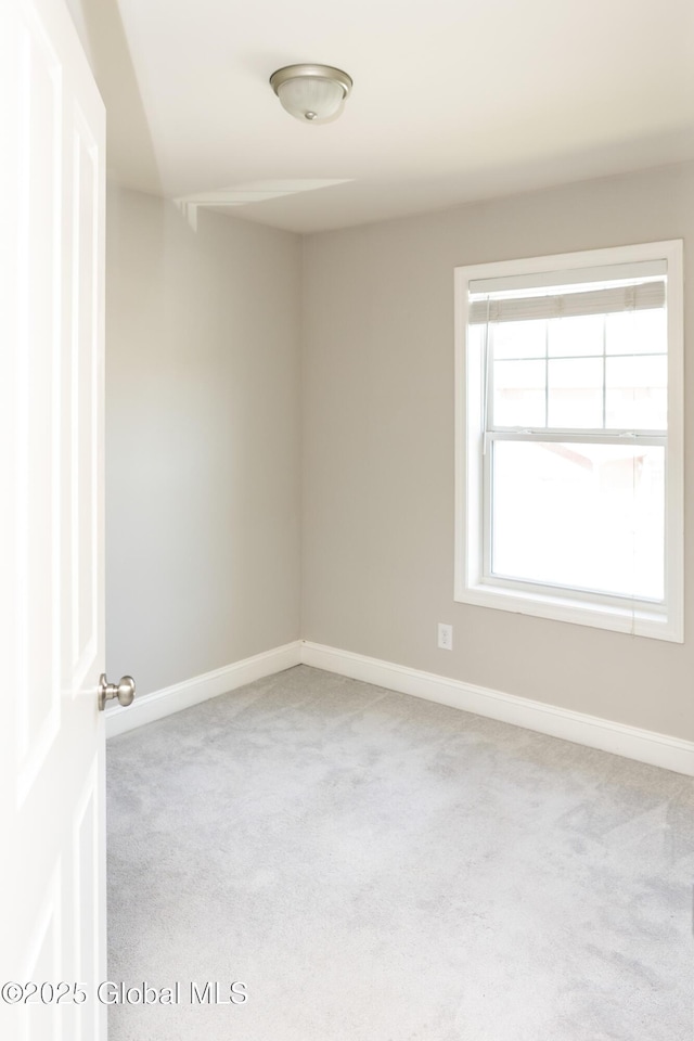 unfurnished room with carpet and baseboards