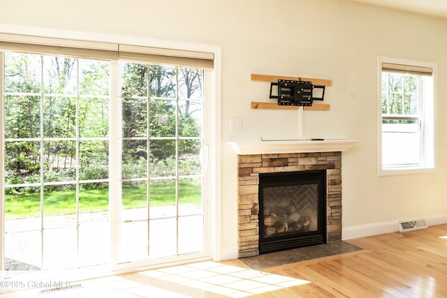 doorway to outside featuring wood finished floors, a fireplace, and baseboards