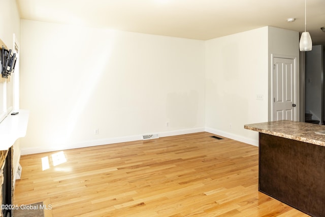 unfurnished dining area with light wood finished floors and baseboards