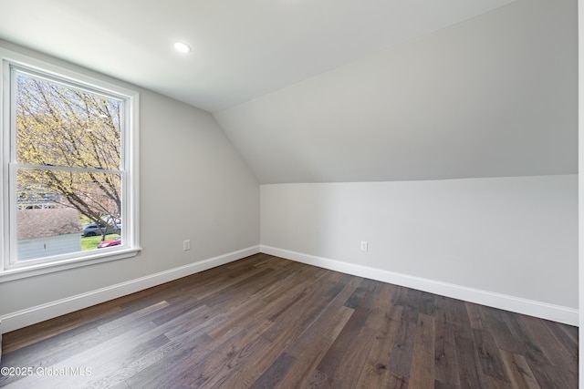 bonus room with lofted ceiling, a healthy amount of sunlight, dark wood-style floors, and baseboards