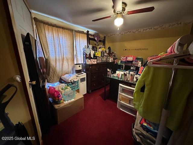 interior space with dark colored carpet and ceiling fan