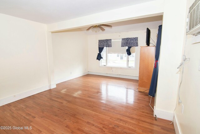 empty room with baseboards, a ceiling fan, and wood finished floors
