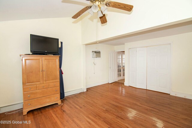 interior space with baseboards, a ceiling fan, wood finished floors, and high vaulted ceiling