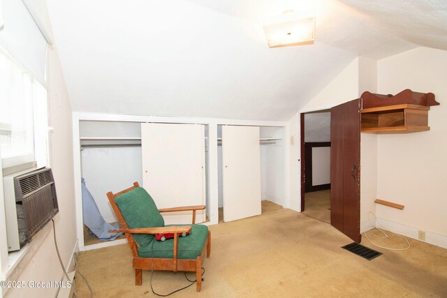 living area with visible vents, carpet, and lofted ceiling