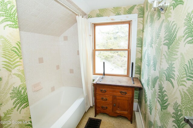 bathroom with plenty of natural light, vaulted ceiling, shower / tub combo, and wallpapered walls