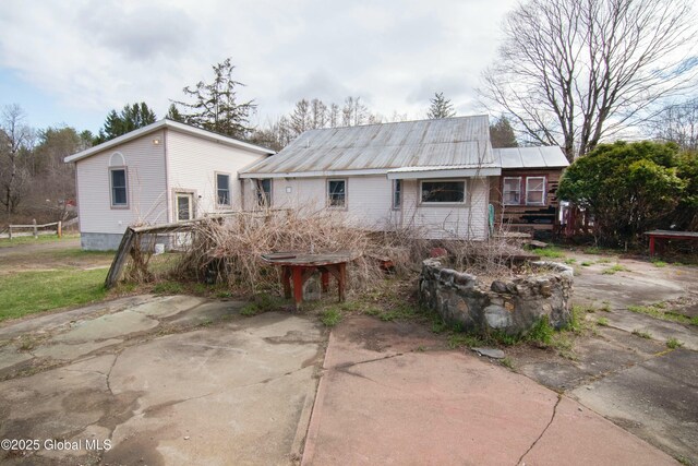rear view of house featuring metal roof