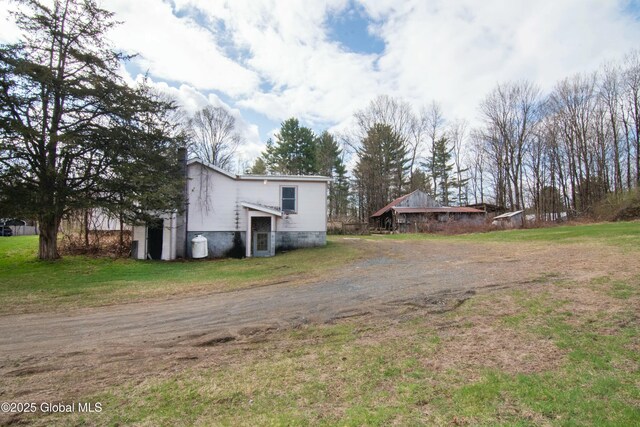 exterior space featuring a yard and dirt driveway