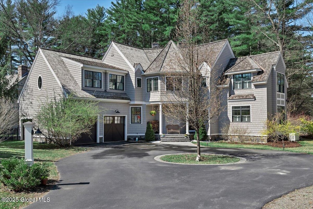1 Joshua Rd, Saratoga Springs, NY 12866 - shingle-style home featuring a garage, central air condition unit, driveway, and roof with shingles