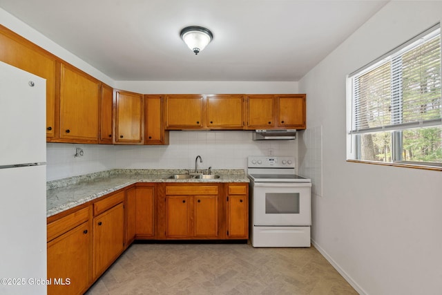kitchen with brown cabinets, a sink, white appliances, decorative backsplash, and under cabinet range hood