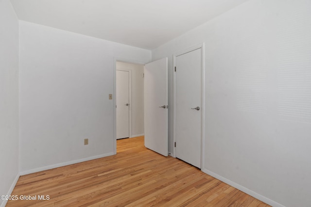empty room with light wood-type flooring and baseboards