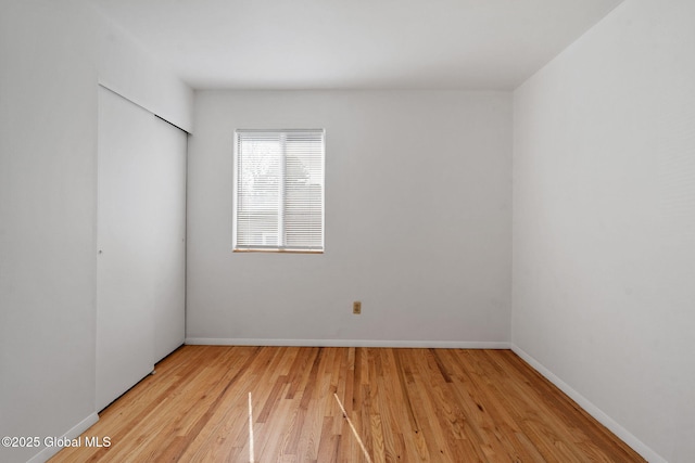 empty room with light wood-style floors and baseboards