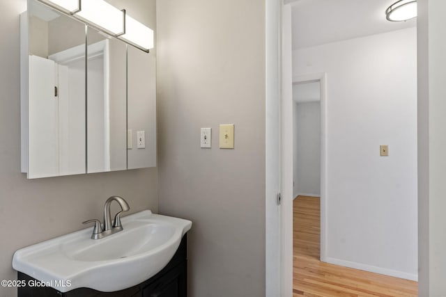 bathroom with baseboards, vanity, and wood finished floors