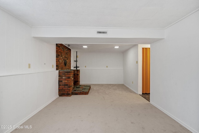 finished basement with visible vents, ornamental molding, and carpet