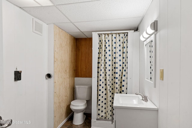 bathroom featuring vanity, a drop ceiling, and toilet