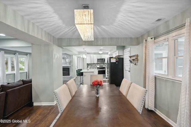 1094 Deforest St, Rotterdam, NY 12303 - dining room with a chandelier, baseboards, dark wood-style floors, and a glass covered fireplace
