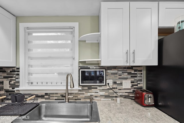 1094 Deforest St, Rotterdam, NY 12303 - kitchen with backsplash, white cabinetry, a sink, and light stone countertops