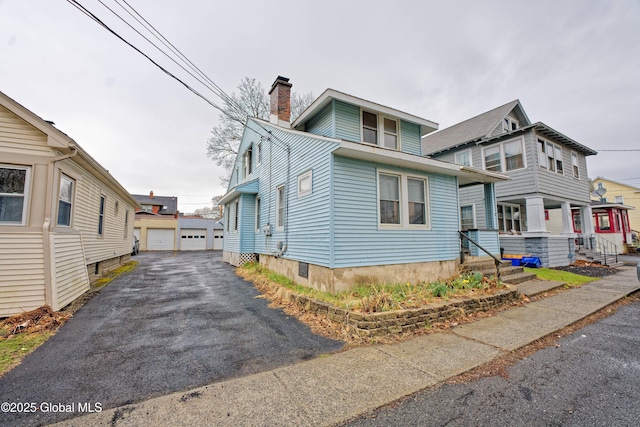 1823 8th St, Rensselaer, NY 12144 - view of front facade featuring a chimney, an outbuilding, and a garage