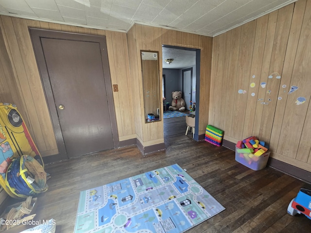 interior space with wood walls, ornamental molding, hardwood / wood-style floors, and baseboards