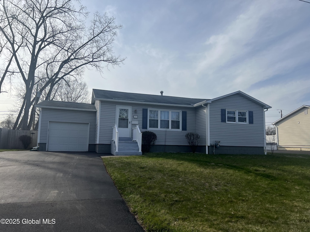 ranch-style house featuring an attached garage, a front lawn, driveway, and fence