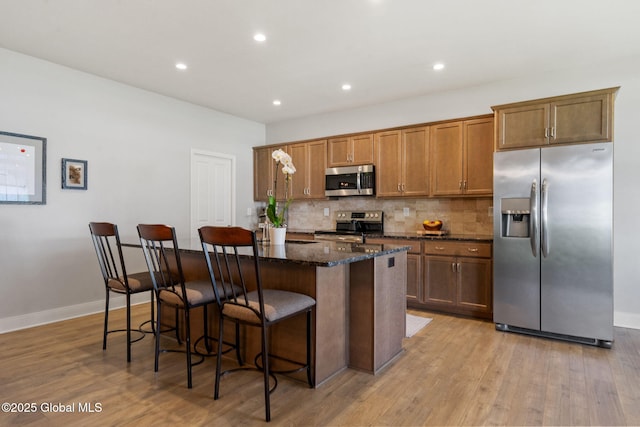6 Gorsline Dr, Halfmoon, NY 12118 - kitchen featuring tasteful backsplash, dark stone countertops, a breakfast bar area, stainless steel appliances, and a kitchen island