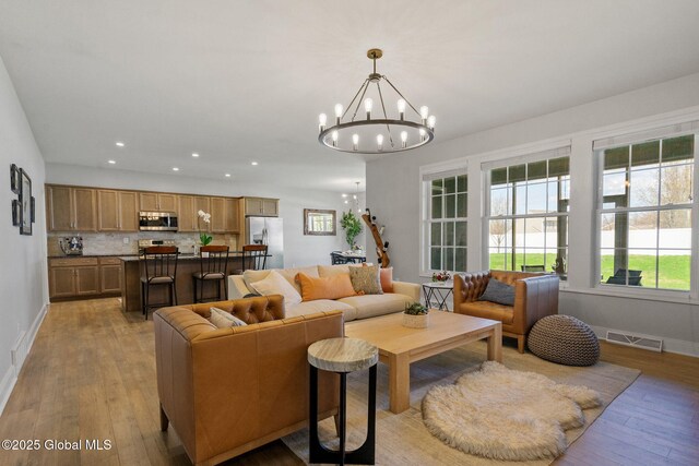 6 Gorsline Dr, Halfmoon, NY 12118 - living room featuring recessed lighting, visible vents, light wood-type flooring, baseboards, and a notable chandelier