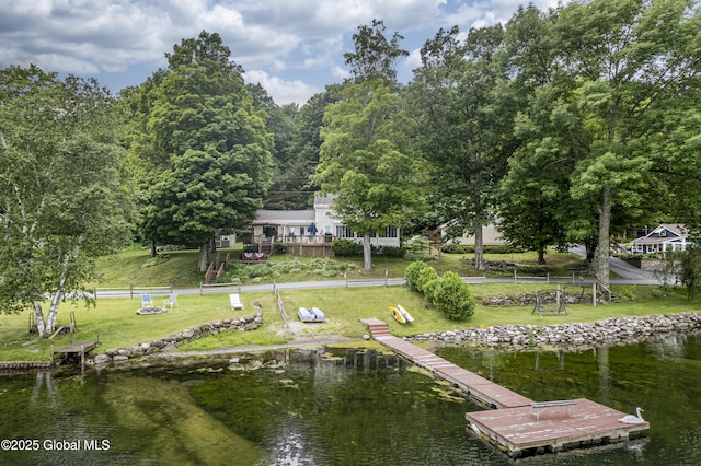 view of dock featuring a lawn and a water view