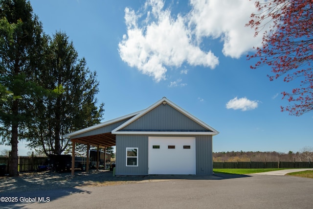 garage with fence and a detached garage