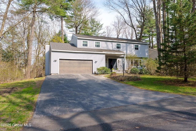 traditional home featuring an attached garage and aphalt driveway