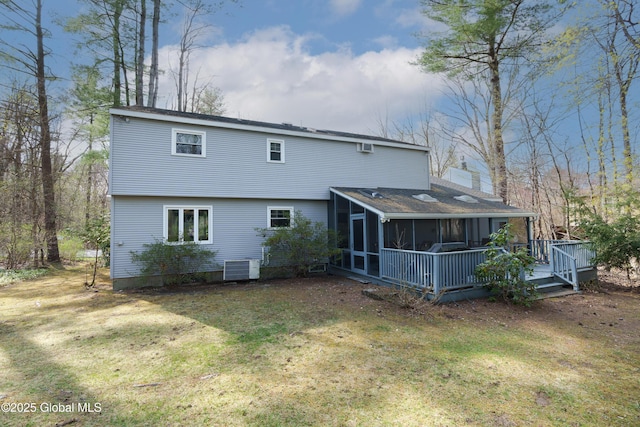 back of property featuring a wooden deck, central AC, a chimney, a sunroom, and a lawn
