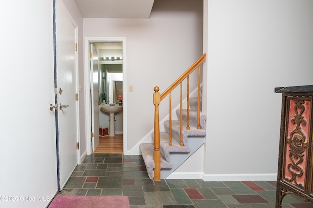 interior space with baseboards, stone finish flooring, and stairway
