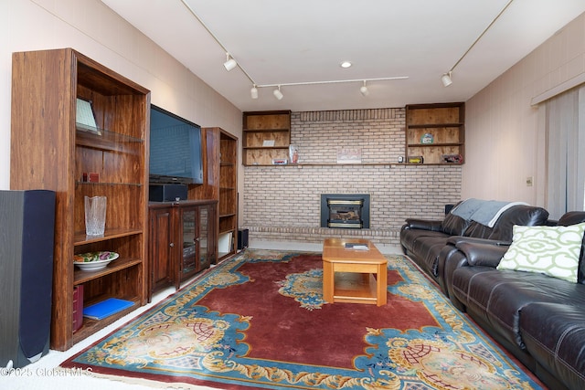 living area featuring a brick fireplace and rail lighting