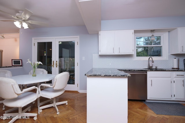 kitchen with a sink, stainless steel dishwasher, french doors, and white cabinetry