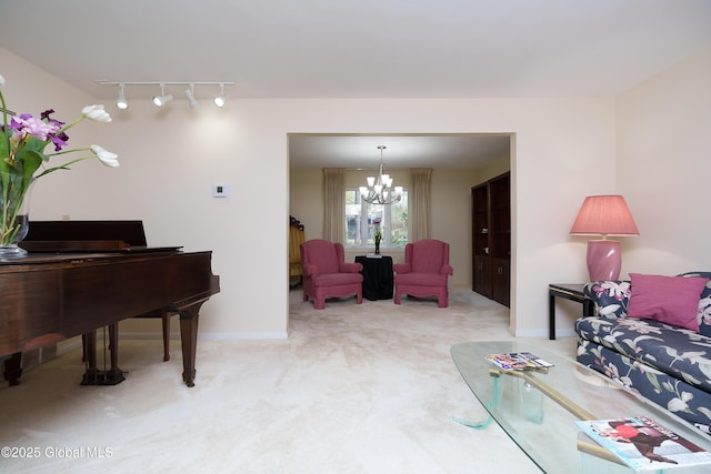 living area with track lighting, baseboards, carpet, and a chandelier