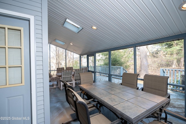 sunroom featuring outdoor dining area and a wealth of natural light