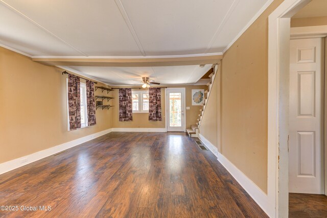 unfurnished room with stairway, a ceiling fan, baseboards, dark wood-type flooring, and visible vents