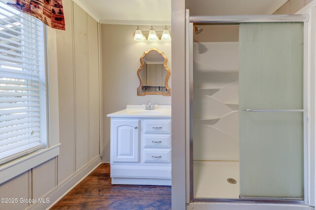 full bathroom with wood finished floors, vanity, and a stall shower