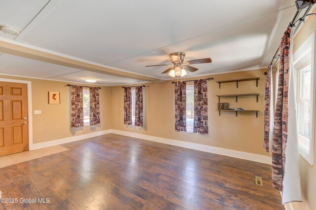 unfurnished room with plenty of natural light, a ceiling fan, and wood finished floors