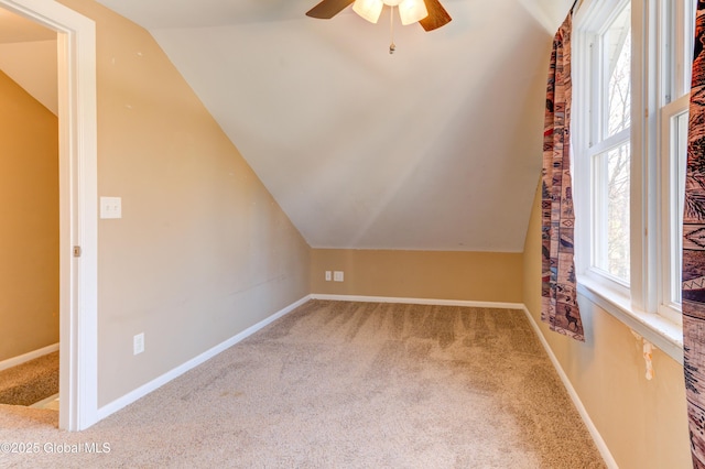 additional living space featuring vaulted ceiling, carpet, baseboards, and ceiling fan