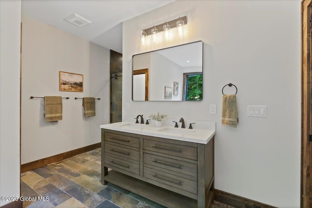 1181 Hunt Lake Rd Unit N, Corinth, NY 12822 - bathroom with double vanity, stone tile floors, baseboards, and a sink